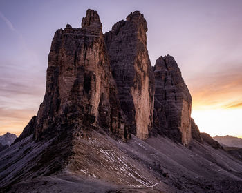 Rock formation on mountain against sky during sunset