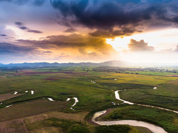 Scenic landscape aerial view of field river and basin against a natural mountain