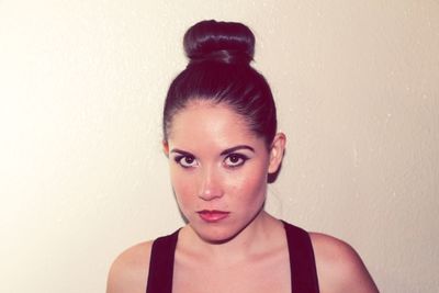 Close-up portrait of young woman against white background