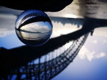 Upside down of crystal ball against bridge