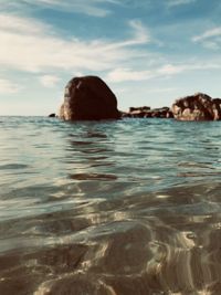 Rock formation in sea against sky