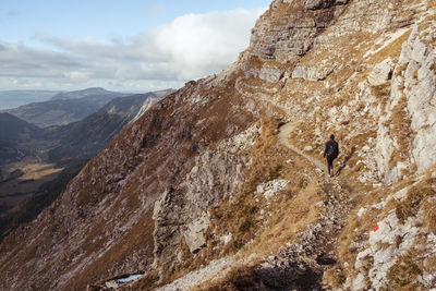 Rear view of woman walking on mountain ridge