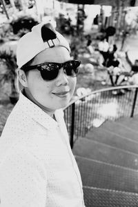 Portrait of woman wearing sunglasses while standing on staircase