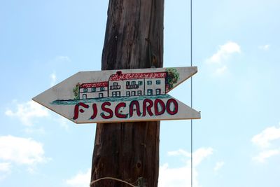 Low angle view of sign board against cloudy sky