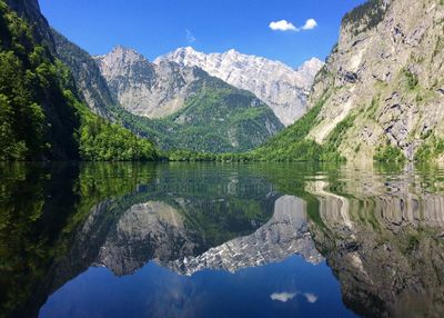 Scenic view of lake and mountains against blue sky