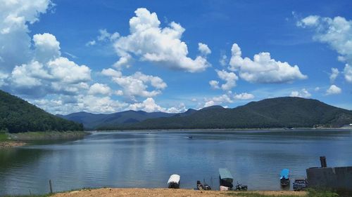 Scenic view of lake by mountains against sky