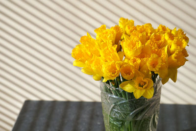 Close-up of yellow flower pot on table