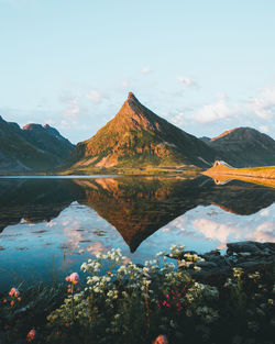 Scenic view of lake by mountains against sky