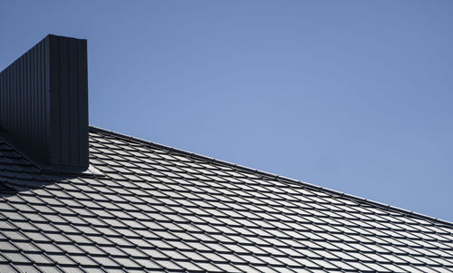 Low angle view of modern building against clear blue sky