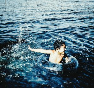 Boy with inflatable ring enjoying in sea