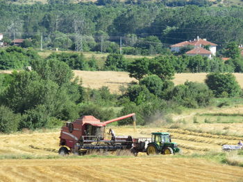 Tractor on field against trees