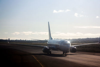 Airplane on runway against sky