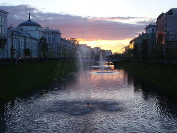 Buildings at waterfront during sunset