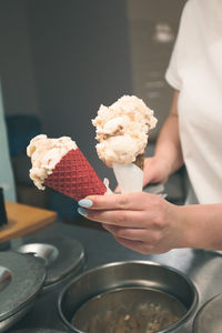 Seller selling couple scoops of ice cream in a candy shop by a street