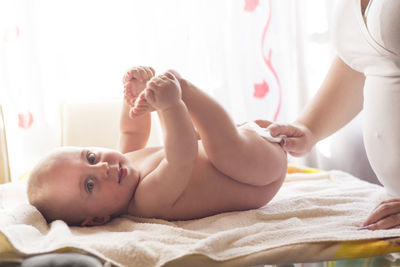 Midsection of woman lying on bed