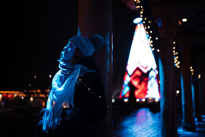 Man looking at illuminated lighting equipment at night