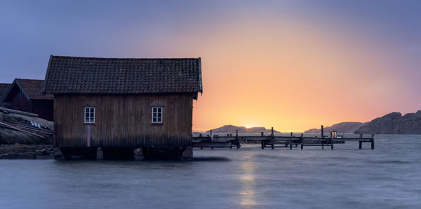 Scenic view of sea and buildings against sky during sunset