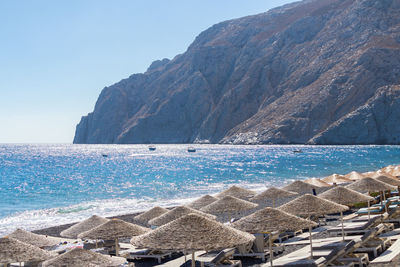 Aerial view of sea and mountains against blue sky