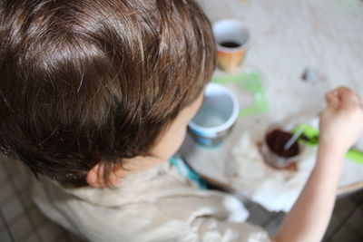 High angle view portrait of boy holding coffee