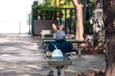 Rear view of man sitting on bench