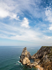 Rock formations by sea against sky