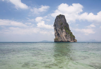 Rock formation in sea against sky