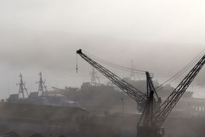 Cranes at construction site against sky