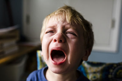 Close-up of boy crying at home