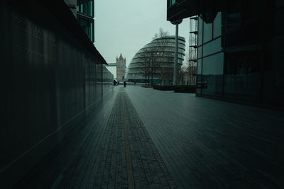 Empty road amidst buildings in city