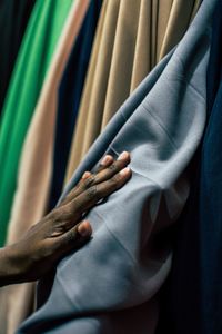 Cropped hand of man touching fabric at shop