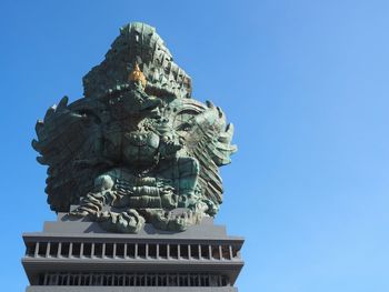 Garuda wisnu statue in bali, indonesia. with clear sky background. space for text