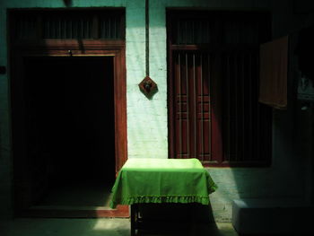 Opened wooden door in sunlight and a table in front