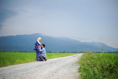 Woman on road by mountain against sky