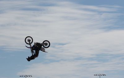 Man performing extreme stunt with motorcycle in mid-air