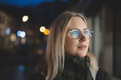Woman with glasses in front of store window