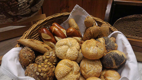 Various fresh bun and loafs of bread in wicker basket