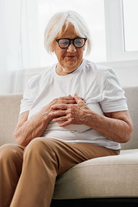 Low angle view of woman sitting on sofa at home