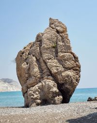 Rock formation on beach against clear sky