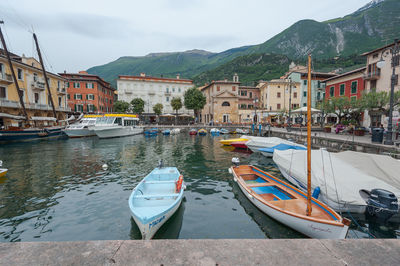 Boats moored on river by buildings in city