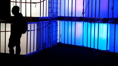 Silhouette of man standing against white wall