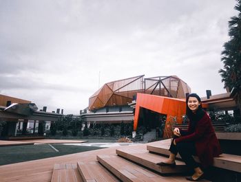 Portrait of woman sitting against sky