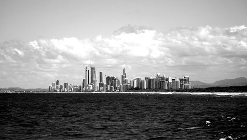 Calm sea with buildings in background