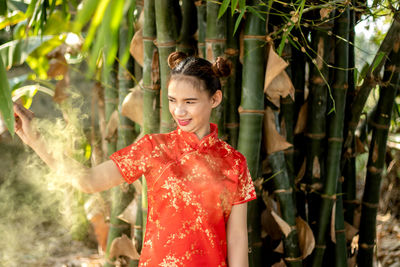 Young woman standing by plants