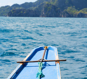 Close-up of boat on sea against mountain