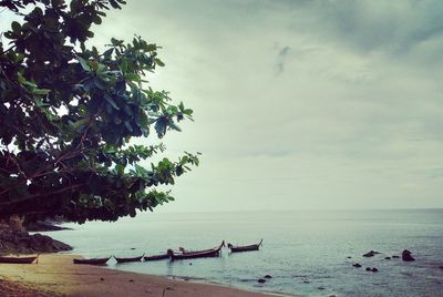 Scenic view of beach against cloudy sky