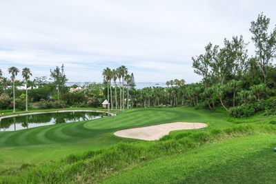 Scenic view of golf course against sky