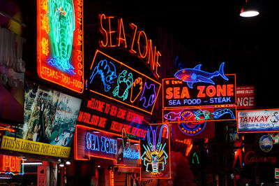 Low angle view of illuminated signboards at night