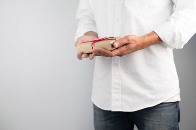 Midsection of man standing against white background