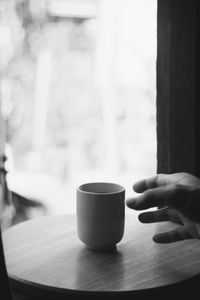 Person holding coffee cup on table