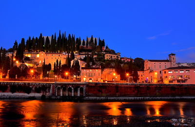 Illuminated buildings against sky at night